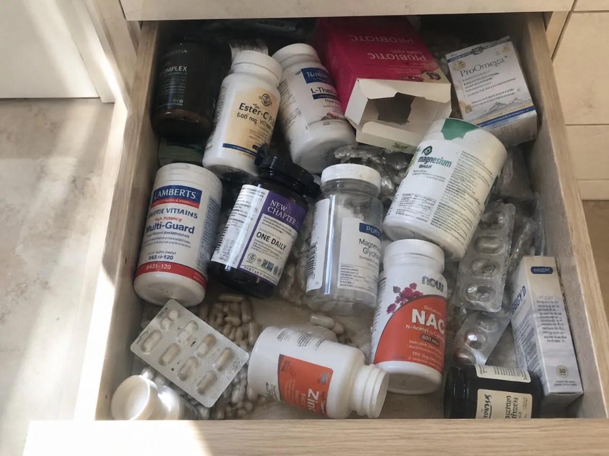 A bathroom drawer of assorted supplement bottles and blister packs