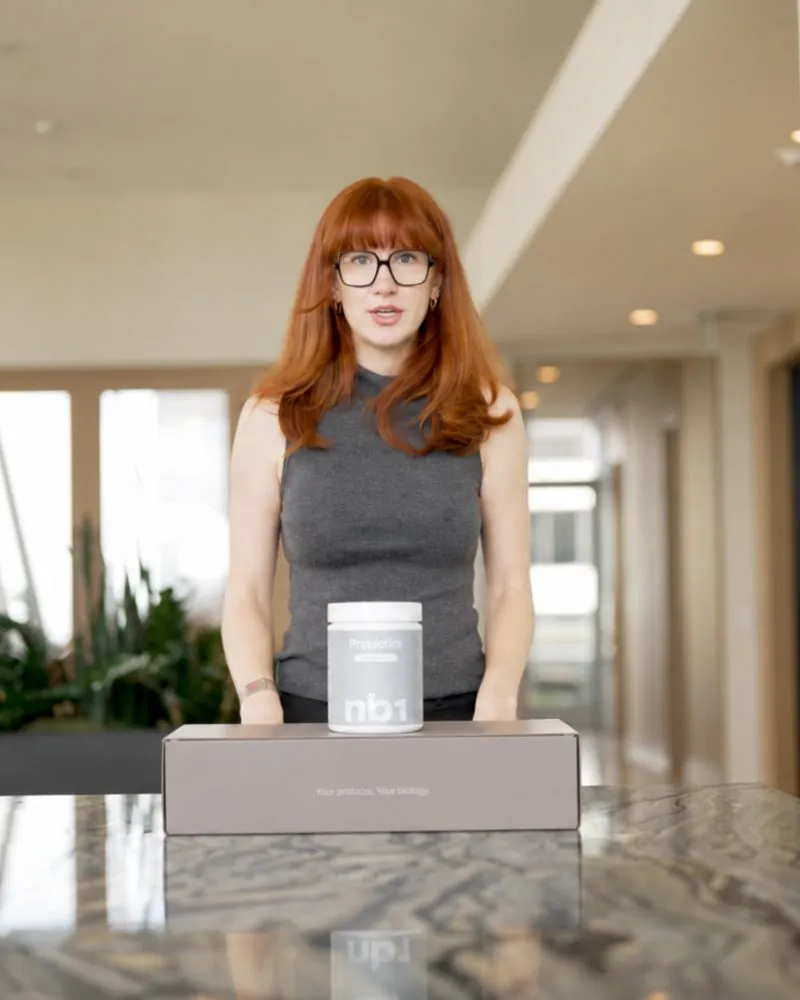 A member at a kitchen counter with the nb1 kit box and the Nourish tub