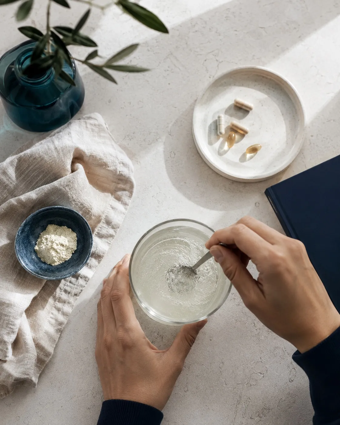 Overhead of a daily supplement ritual, stirring powder into water